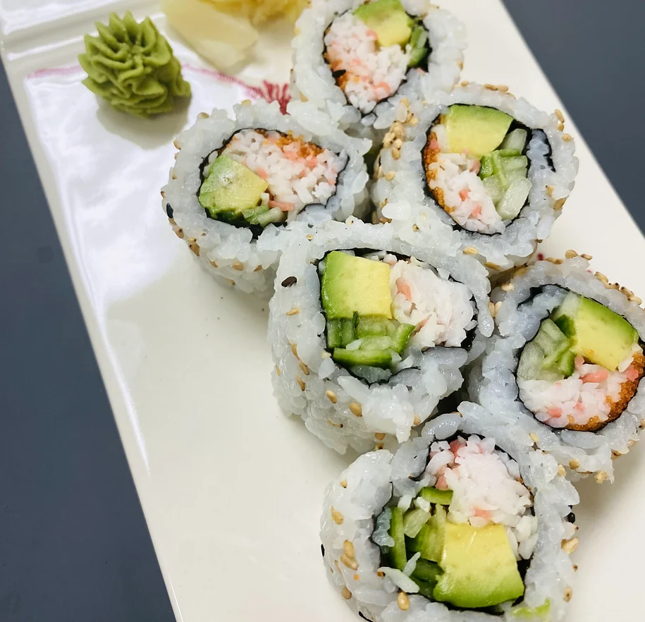 California roll pieces with imitation crab, avocado and cucumber on a white plate with ginger and wasabi at Hana Sushi, Winnipeg